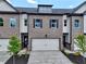 Charming townhome exterior featuring a brick facade, attached garage, and well-manicured landscaping at 5702 Urban Village Way # 2, Tucker, GA 30084