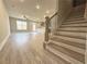 Open-concept living space with wood-look floors, staircase, and a glimpse into the kitchen area at 5702 Urban Village Way # 2, Tucker, GA 30084