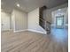 Spacious living room with wood-look floors, staircase, and an open layout leading to the entryway at 5702 Urban Village Way # 2, Tucker, GA 30084