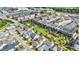 An aerial view of a neighborhood featuring modern townhomes, a manicured green, and tree-lined streets at 6645 Cortland Walk, Alpharetta, GA 30005