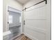 Stylish white barn door leading to a bedroom with hardwood floors, adding charm and functionality to the space at 6645 Cortland Walk, Alpharetta, GA 30005