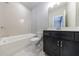 Elegant bathroom with a tiled shower-tub combo, dark vanity, and modern fixtures, creating a relaxing space at 6645 Cortland Walk, Alpharetta, GA 30005