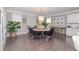 Elegant dining area features a round table, dark wood floors, and natural light from the nearby windows at 2720 Garonne Way, Cumming, GA 30041