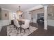 Bright dining room with a modern chandelier, hardwood floors, and an adjoining home office at 2720 Garonne Way, Cumming, GA 30041
