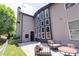 A back exterior view showing a patio, large windows, and lush landscaping at 2720 Garonne Way, Cumming, GA 30041