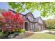 Beautiful two-story home featuring a landscaped yard and an arched entryway at 2720 Garonne Way, Cumming, GA 30041