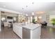 Open concept kitchen featuring an island with stainless steel dishwasher and view into the adjacent dining and living areas at 2720 Garonne Way, Cumming, GA 30041