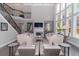 Bright, airy living room boasts soaring ceilings, large windows, and a cozy fireplace with staircase leading to the upper level at 2720 Garonne Way, Cumming, GA 30041
