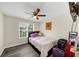 This bedroom offers a single window, ceiling fan and wood-look flooring at 2880 Field Spring Dr, Lithonia, GA 30058