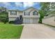 Charming split-level home featuring a two-car garage and freshly manicured lawn at 2880 Field Spring Dr, Lithonia, GA 30058