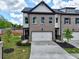 Beautiful townhome featuring a brick facade, attached garage, and landscaped front yard at 5700 Urban Village Way # 1, Tucker, GA 30084