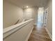 Upstairs hallway featuring luxury vinyl plank flooring and neutral paint at 5700 Urban Village Way # 1, Tucker, GA 30084