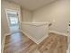 Upstairs landing and hallway with luxury vinyl plank flooring and white railing at 5700 Urban Village Way # 1, Tucker, GA 30084