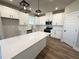 Modern kitchen features white cabinets, quartz countertops, and stylish pendant lighting at 5700 Urban Village Way # 1, Tucker, GA 30084