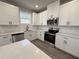 Bright kitchen with white cabinets, stainless steel appliances, and quartz countertops at 5700 Urban Village Way # 1, Tucker, GA 30084