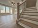 Carpeted staircase with decorative black metal railing and wood handrail, with light-colored walls at 5700 Urban Village Way # 1, Tucker, GA 30084