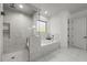 The bathroom has a separate shower and soaking tub with white marble throughout at 885 Old Peachtree Ne Rd, Lawrenceville, GA 30043
