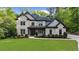 Two-story brick home with a manicured lawn, driveway, and an attached garage surrounded by green trees at 885 Old Peachtree Ne Rd, Lawrenceville, GA 30043
