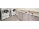 Well-equipped laundry room features front-load washer and dryer, with stylish countertops and modern cabinets at 885 Old Peachtree Ne Rd, Lawrenceville, GA 30043