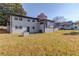 Large grassy backyard with trees, and view of the home's back exterior at 2103 Columbia Dr, Decatur, GA 30032