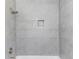 Bathroom shower featuring elegant gray tile and a convenient recessed shelf at 2103 Columbia Dr, Decatur, GA 30032