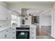 This kitchen features stainless appliances, white cabinets, and modern range hood at 2103 Columbia Dr, Decatur, GA 30032
