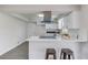 Modern kitchen with white cabinets, breakfast bar seating, and stainless steel range hood at 2103 Columbia Dr, Decatur, GA 30032