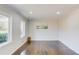Bright room with hardwood floors, two windows, and a minimalist art print at 2103 Columbia Dr, Decatur, GA 30032