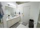 Bright bathroom with double sinks, white cabinets, white door, and decorative gray rugs at 2840 General Lee Way, Buford, GA 30519