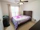 Bedroom features ceiling fan, natural light, neutral tones, and a decorative purple floral comforter at 2840 General Lee Way, Buford, GA 30519