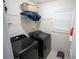This laundry room has a front load washer and dryer, tile flooring, and a storage shelf at 2840 General Lee Way, Buford, GA 30519