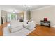 Comfortable living room with hardwood floors, large windows, and a cozy white sectional sofa at 3642 Princeton Ave, Atlanta, GA 30337