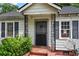 Close-up of the charming front porch with decorative ironwork and brick steps at 1377 Pine Ave, Atlanta, GA 30344