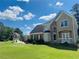 Charming two-story home with a well-manicured lawn, brick accents, and lush landscaping on a sunny day at 479 Rising Sun Path, Lawrenceville, GA 30043