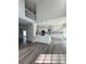Open floor plan with a modern kitchen featuring white cabinetry, a center island, and stylish pendant lighting at 479 Rising Sun Path, Lawrenceville, GA 30043