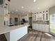 Bright, modern kitchen with white cabinetry, quartz countertops, and stainless steel appliances overlooking the spacious living area at 479 Rising Sun Path, Lawrenceville, GA 30043