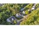 Aerial view of landscaped homes, winding creek and road nestled between lush trees and greenery at 6150 Bridge Fair Rd, Cumming, GA 30028
