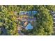 Aerial view of community amenities including swimming pool, tennis courts, sports field, and clubhouse surrounded by trees at 6150 Bridge Fair Rd, Cumming, GA 30028