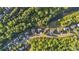 Aerial view of community lined with lush trees and a winding creek near beautifully landscaped homes at 6150 Bridge Fair Rd, Cumming, GA 30028