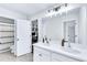 Bathroom featuring double sinks, white cabinets, a large mirror, and two entrances to other rooms at 6150 Bridge Fair Rd, Cumming, GA 30028