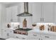 Modern kitchen features white cabinets, quartz countertops, stainless steel hood, and subway tile backsplash at 6150 Bridge Fair Rd, Cumming, GA 30028