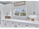 Bright kitchen featuring white cabinetry, subway tile backsplash, quartz countertop, and a large window at 6150 Bridge Fair Rd, Cumming, GA 30028