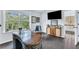 An executive office with a curved wood desk and large window allows for natural light and views of a wooded lot at 6150 Bridge Fair Rd, Cumming, GA 30028