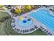 Aerial view of a community pool and splashpad featuring colorful umbrellas surrounded by lounge chairs at 6150 Bridge Fair Rd, Cumming, GA 30028