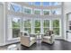 Sunlit sitting area featuring bay windows and two comfortable armchairs overlooking a green landscape at 6150 Bridge Fair Rd, Cumming, GA 30028