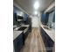 Modern kitchen with blue cabinets, stainless steel appliances, and granite countertops at 123 Rue Fontaine, Lithonia, GA 30038