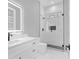 A modern bathroom featuring a glass shower, black fixtures, and white cabinets at 3312 Mill Forest Dr, Conyers, GA 30094