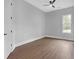 Simple bedroom featuring neutral walls, wood floors, a ceiling fan, and a large window at 3312 Mill Forest Dr, Conyers, GA 30094