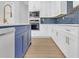Modern kitchen with white cabinets, blue backsplash, stainless steel appliances, and a central island at 3312 Mill Forest Dr, Conyers, GA 30094