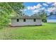 Expansive backyard featuring lush green grass and a white exterior with views of mature trees at 4384 Raven Valley Ct, Decatur, GA 30035